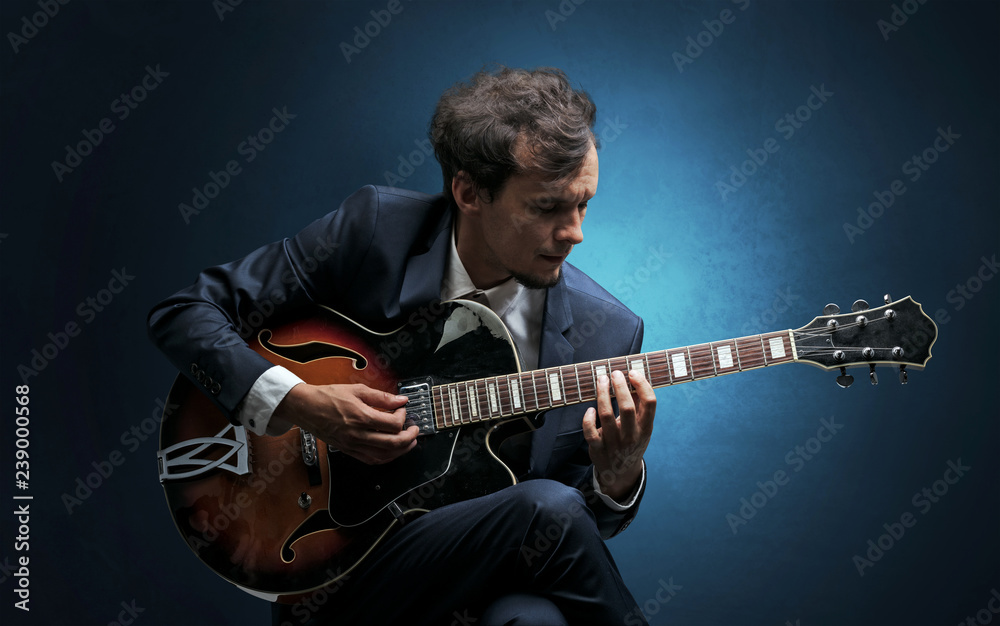 Obraz premium Lonely guitarist composing on cello with nothing around 