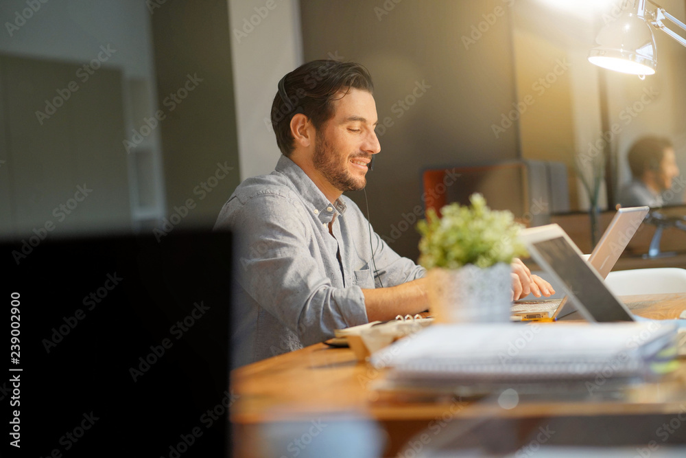 Handsome man smiling in co working space Handsome man smiling in co working space
