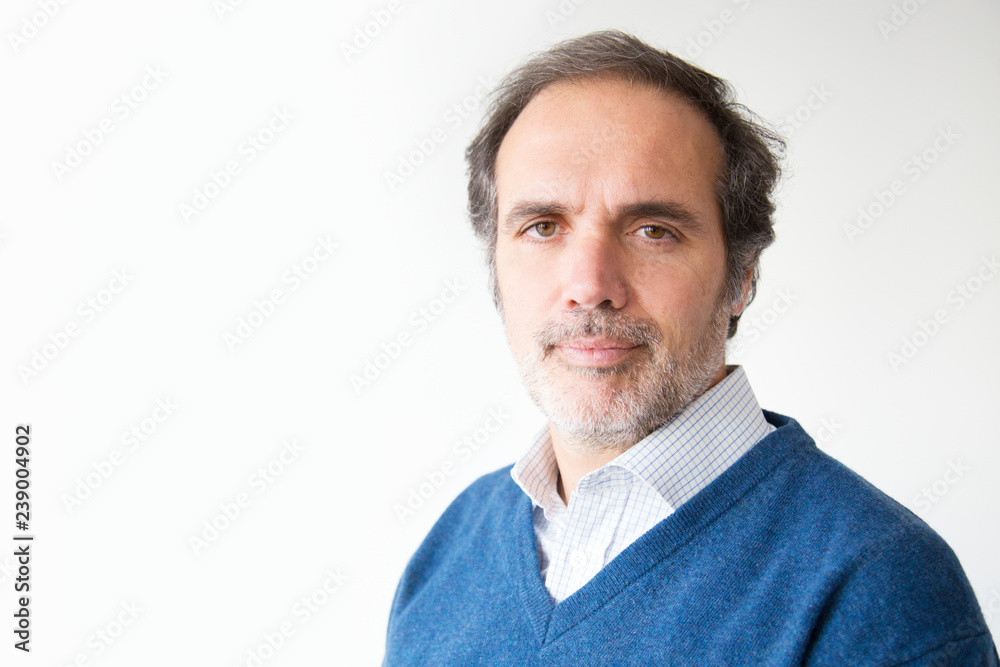 Handsome serious mature man looking at camera. Middle aged man with grey hair and beard posing in blue sweater. Isolated on white. Confidence concept Handsome serious mature man looking at camera. Middle aged man with grey hair and beard posing in blue sweater. Isolated on white. Confidence concept