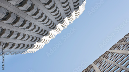 Low angle view of nondescript skyscrapers, or tall office buildings, concept for business space, real estate, urbanization and finance, with pleasing symmetry and copy space 