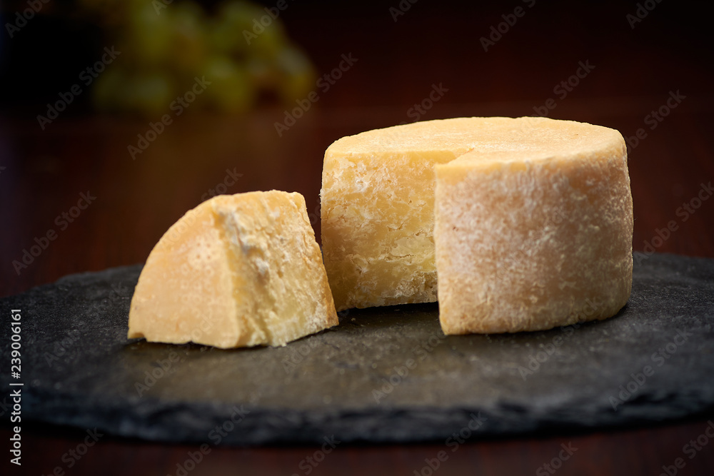 Old weathered cheese on a stone plate