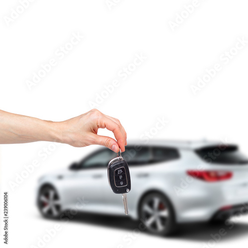 Female hand holds the keys to the new car on the background of the white car