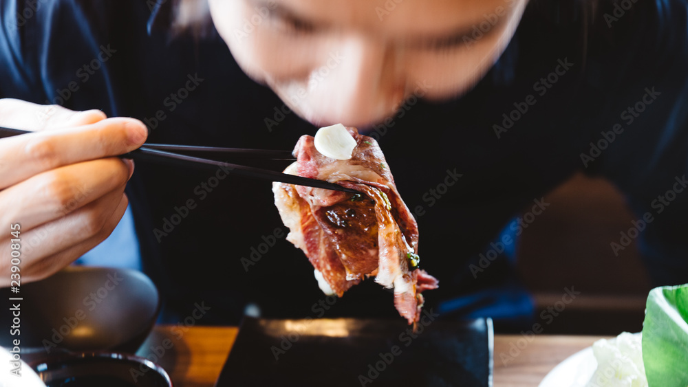 Man eating Touched medium rare sliced authentic A5 Grade Japanese Wagyu beef sushi topping with fresh garlic. Man eating Touched medium rare sliced authentic A5 Grade Japanese Wagyu beef sushi topping with fresh garlic.
