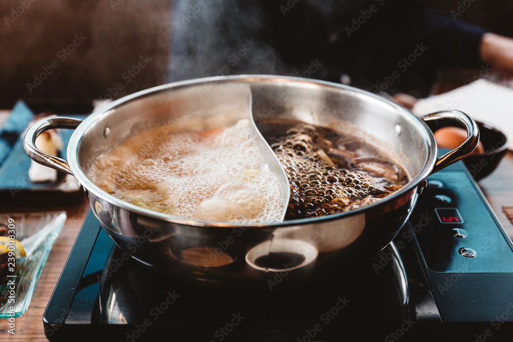 Hot and Boiling Shabu broth: Shoyu soup base and clear soup base in hot pot that ready for boiling beef and vegetables. Hot and Boiling Shabu broth: Shoyu soup base and clear soup base in hot pot that ready for boiling beef and vegetables.