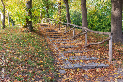 steinerne Treppe mit Holzgeländer in einem herbstlichen Park in Stege