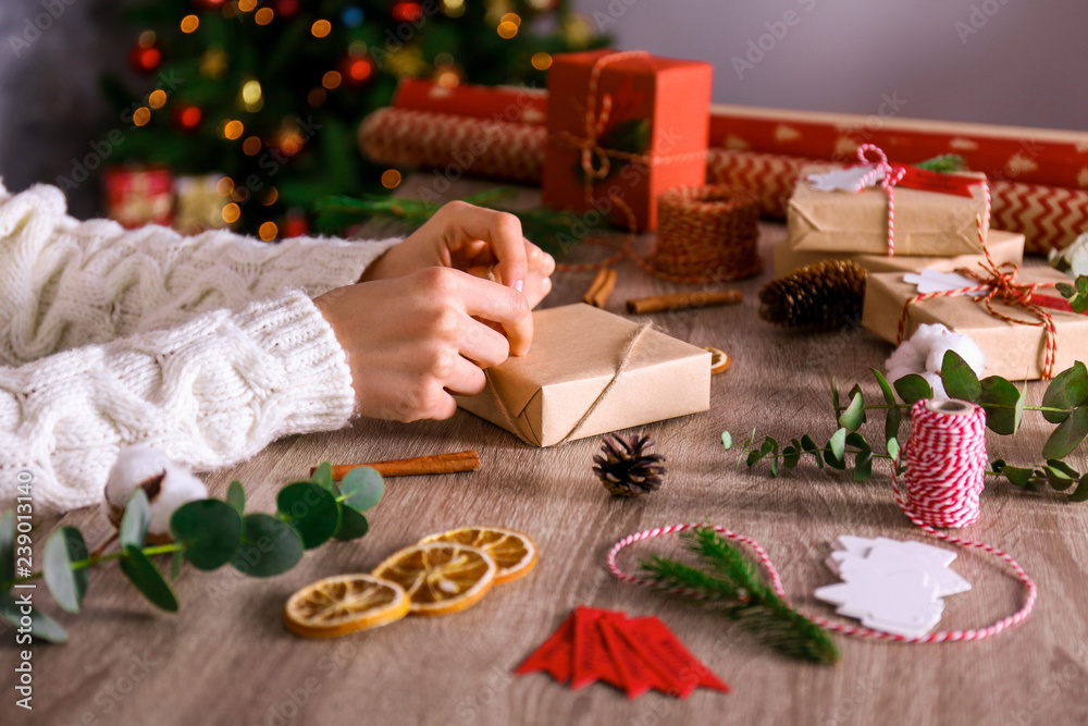 Close up shot of woman prepearing for winter holiday season at her workspace, wrapping christmas presents for family members. Christmas preparation concept. Crop, copy space. Close up shot of woman prepearing for winter holiday season at her workspace, wrapping christmas presents for family members. Christmas preparation concept. Crop, copy space.