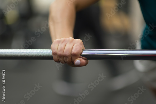 Closeup of female hand holding rod neck. Weightlifting, power lifting or cross fit training.