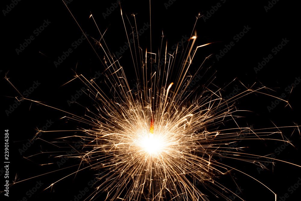 Obraz premium Glittering burning sparkler on Christmas Day and on New Year Day