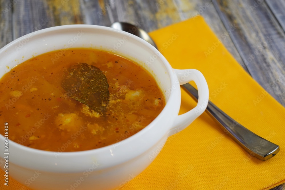 Delicious homemade soup from fresh cabbage on a wooden background.