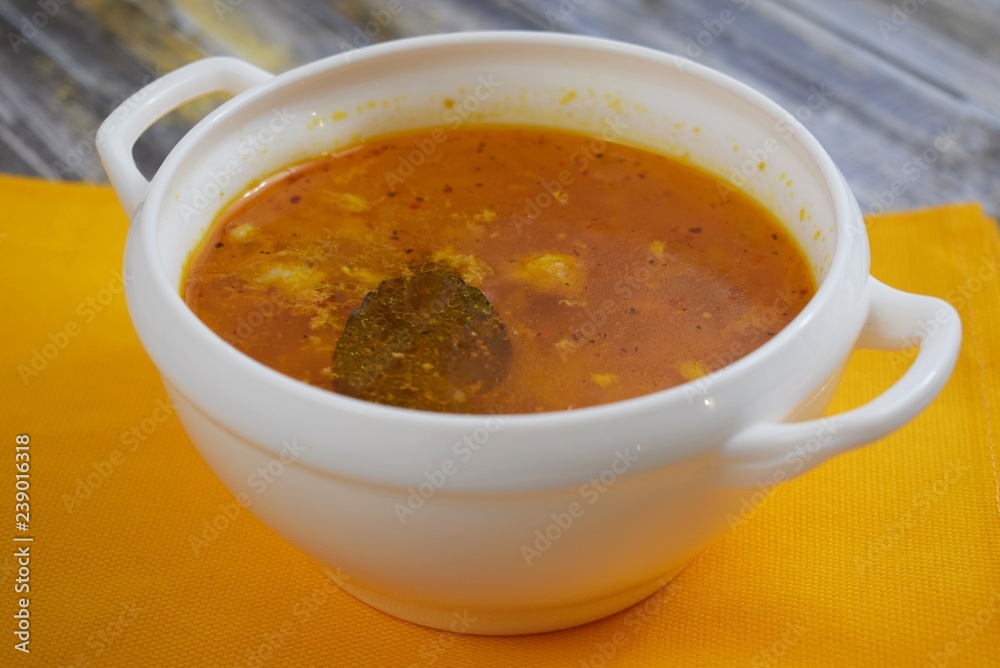 Delicious homemade soup from fresh cabbage on a wooden background.