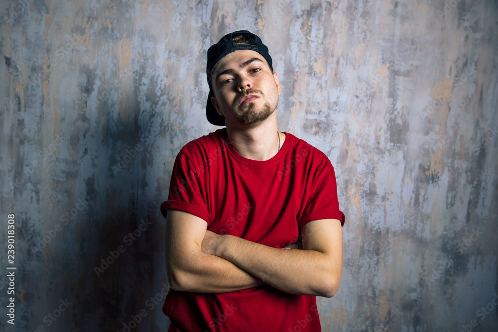 handsome man in fashion clothes posing to the camera. hip hop lovers, street art concept.