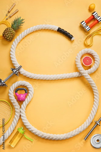 Sports equipment and organic food on yellow background. Top view. Motivation