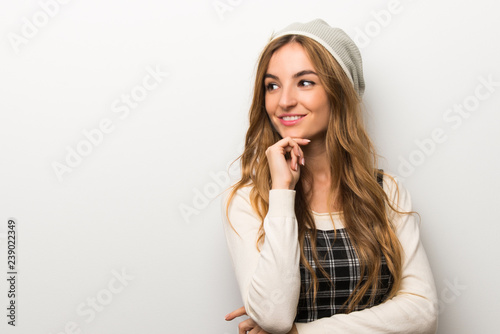 Fashionably woman wearing hat looking to the side with the hand on the chin