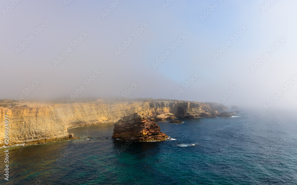 Cliffs on a foggy day near Bordeira beach, Atlantic coast, Portugal