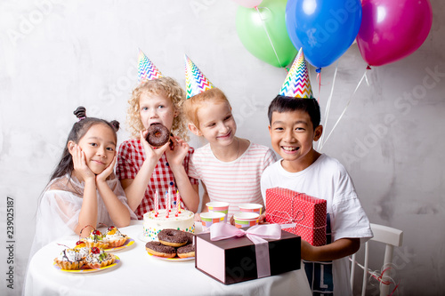 Asian boy holding a red gift box is celebrating his birthday with girls. closeup photo