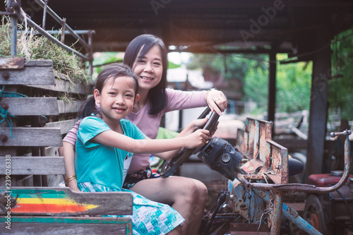 Asian mother and daughter sitting and smilling on the tractor © arrowsmith2