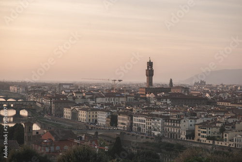 Landscape of the city of Florence, Italy on a long-focus lens, view from the playground on the Arno River and the Palazzo Vecchio in the evening sunset.