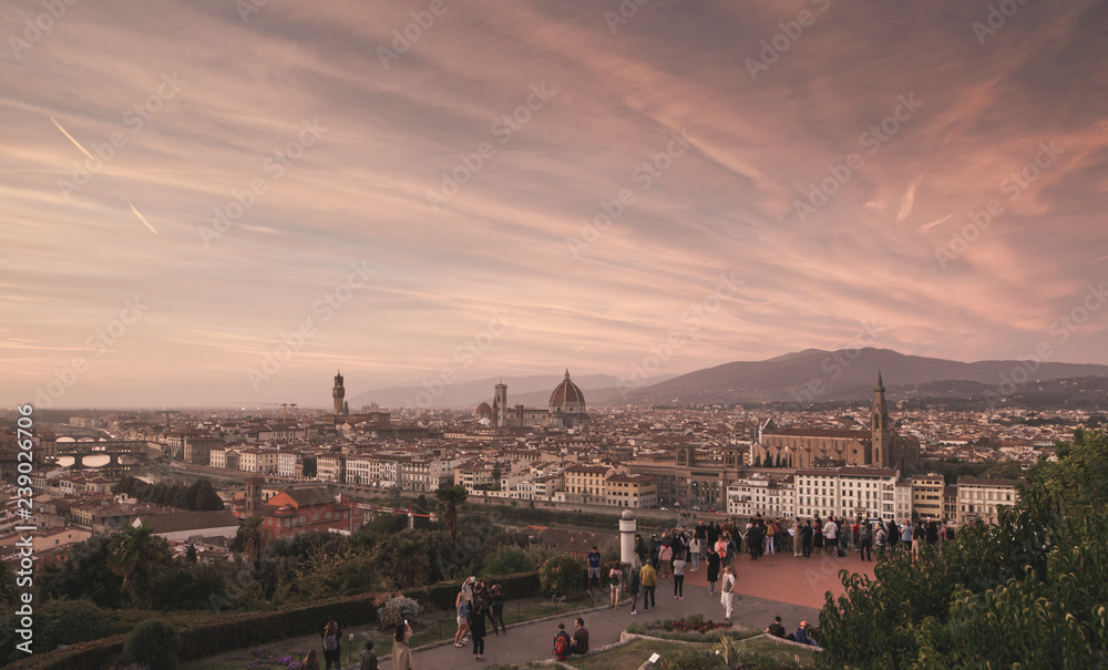 Panoramic landscape of Florence, Italy with a beautiful red sunset and tourists on the viewground. Florence on a beautiful sunset, with an unreal red sky.