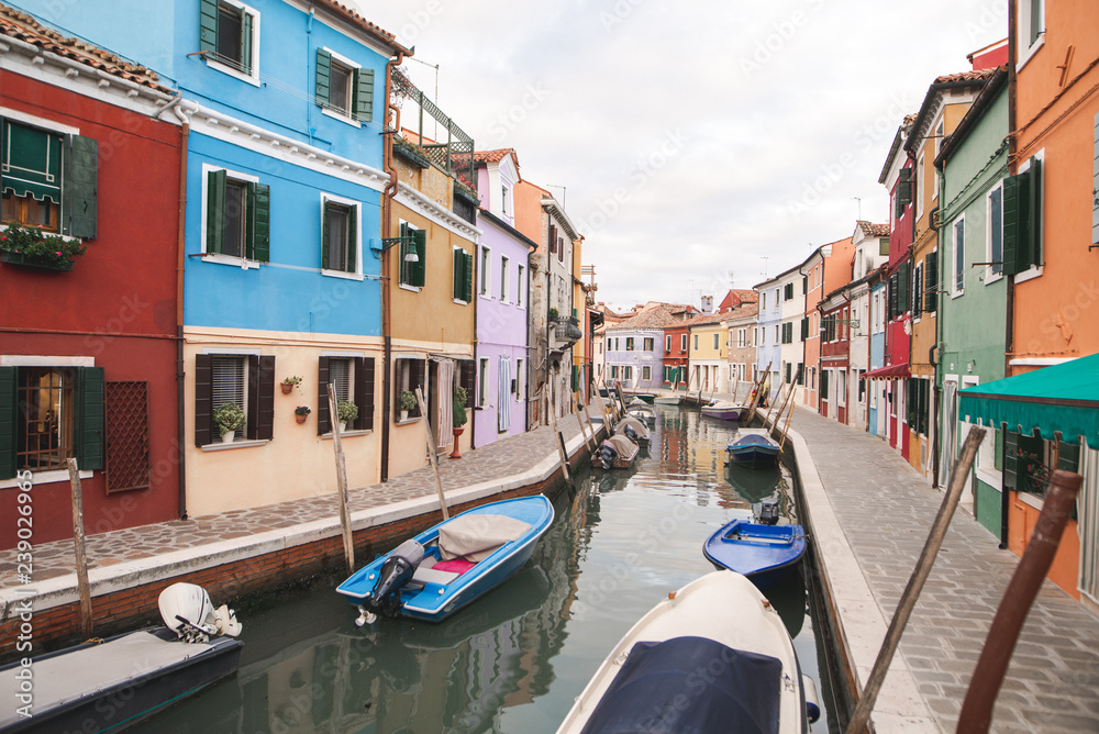 Beautiful landscape of Burano Island. Colored houses, canal and boats in Burano, Venice.