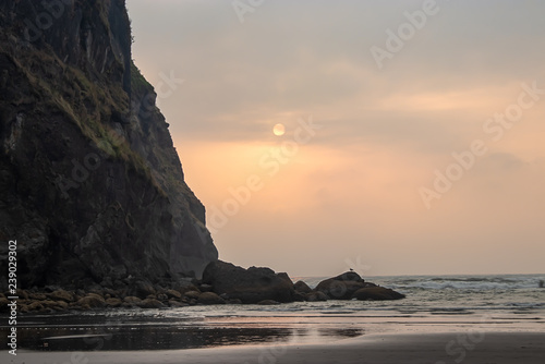 rocks and ocean with evening hazy sunset