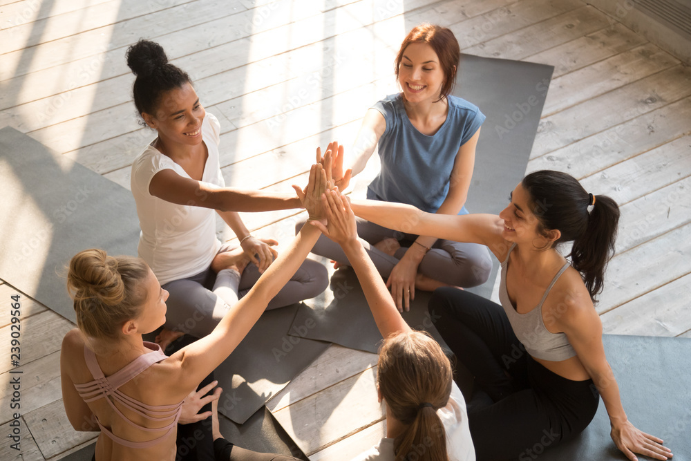 Φωτογραφία Above top view diverse cheerful females wearing sportswear sitting in circle on yoga mats giving high five greeting each other celebrating feel happy and healthy