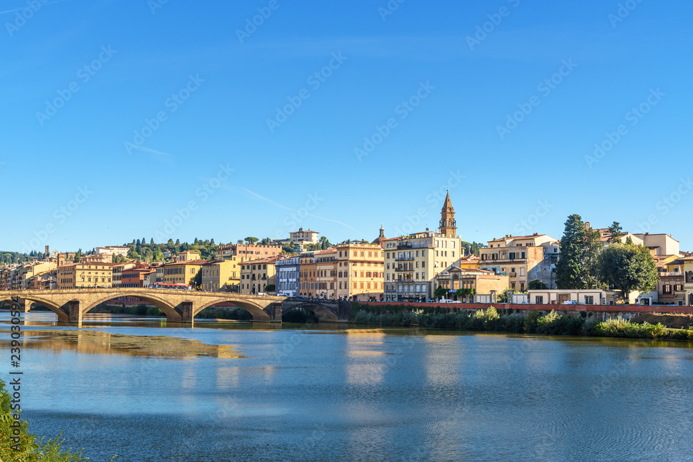 Embankment of Arno river and Ponte Alla Carraia bridge at sunny day in Florence, Italy