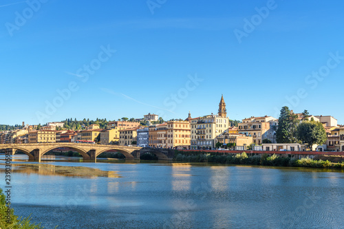 Embankment of Arno river and Ponte Alla Carraia bridge at sunny day in Florence, Italy