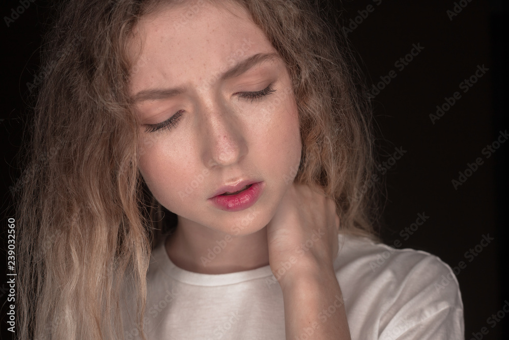 The portrait of a young girl with blonde hair isolated on a brown background The portrait of a young girl with blonde hair isolated on a brown background