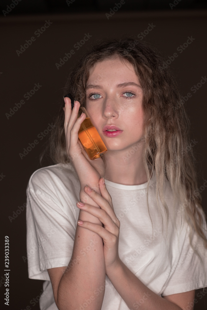 The portrait of a young girl with blonde hair isolated on a brown background The portrait of a young girl with blonde hair isolated on a brown background