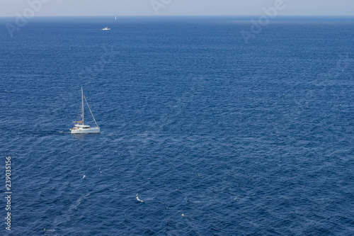 small white yacht in Caribbean water surface with horizon line background wallpaper patter with empty space for copy or your text, expensive summer cruise vacation concept