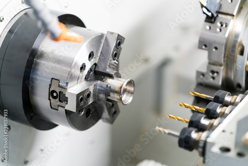 Operator machining automotive part by cnc turning machine,
