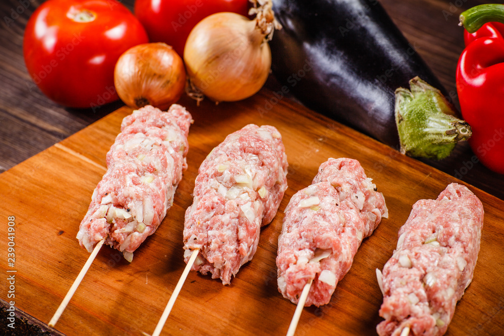 Raw hot dogs on cutting board and vegetables Raw hot dogs on cutting board and vegetables