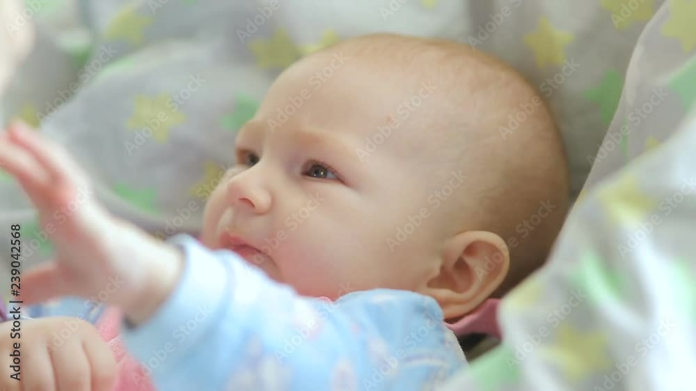 Mum feeds with a spoon her cute newborn baby puree of zucchini closeup Mum feeds with a spoon her cute newborn baby puree of zucchini closeup