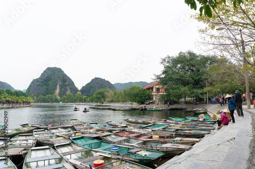 TamCoc, NinhBinh/VietNam, November 25,2017 :  The many traditional bamboo boats are parked and waiting for tourists along the Ngo Dong River of the Tam Coc, Ninh Binh, Vietnam. photo