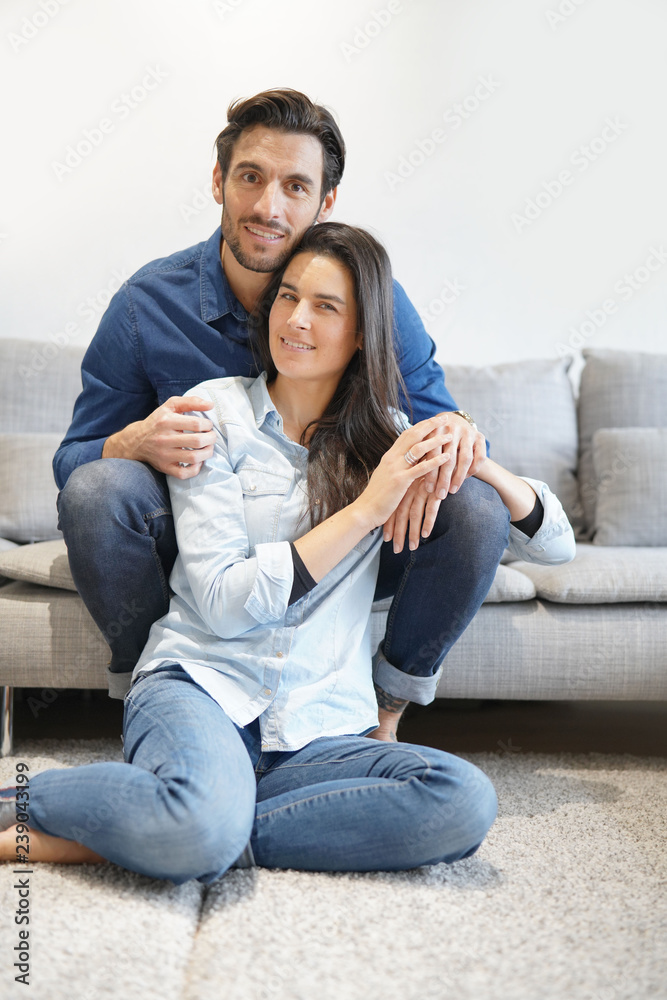 Isolated gorgeous smiling couple in denim on comfy couch Isolated gorgeous smiling couple in denim on comfy couch