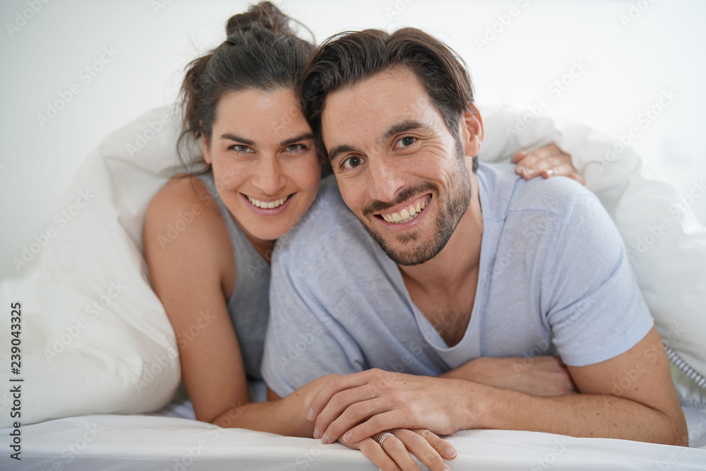 Isolated stunning couple looking at camera smiling in bed Isolated stunning couple looking at camera smiling in bed