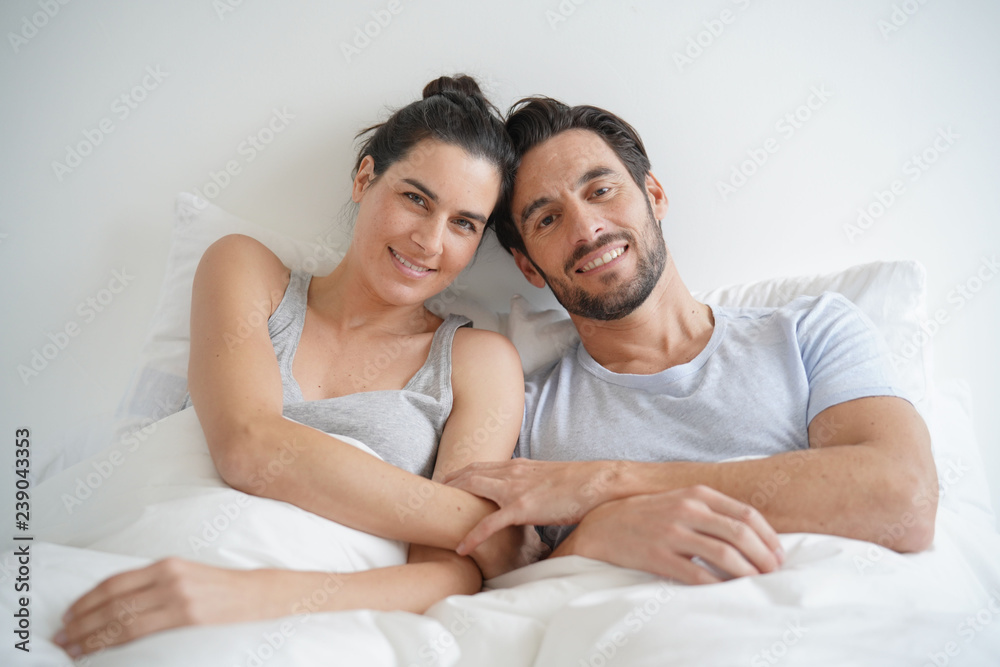Isolated stunning couple looking at camera smiling in bed Isolated stunning couple looking at camera smiling in bed