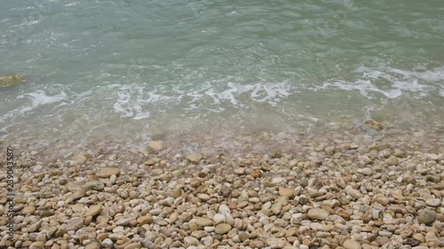 Closeup of sea on stony beach. Closeup seamless, calm and relaxing background. 4k video.