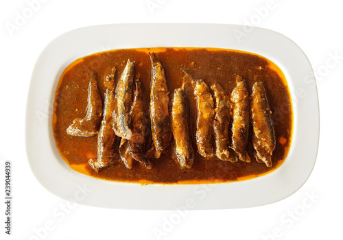 anchovy fish in tomato sauce on a white plate isolated on white background