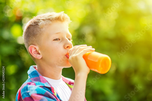 Portrait of a young boy drinking a bottle of juice
