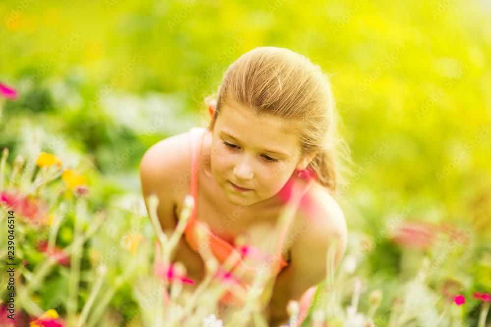 Young girl smelling flowers on the meadow Young girl smelling flowers on the meadow
