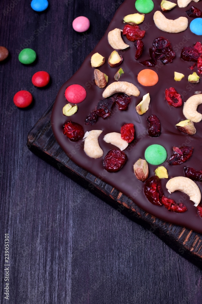 Dark chocolate bark with cashew and pistachio nuts, multicoloured sweets, dried cranberries and cherries Dark chocolate bark with cashew and pistachio nuts, multicoloured sweets, dried cranberries and cherries