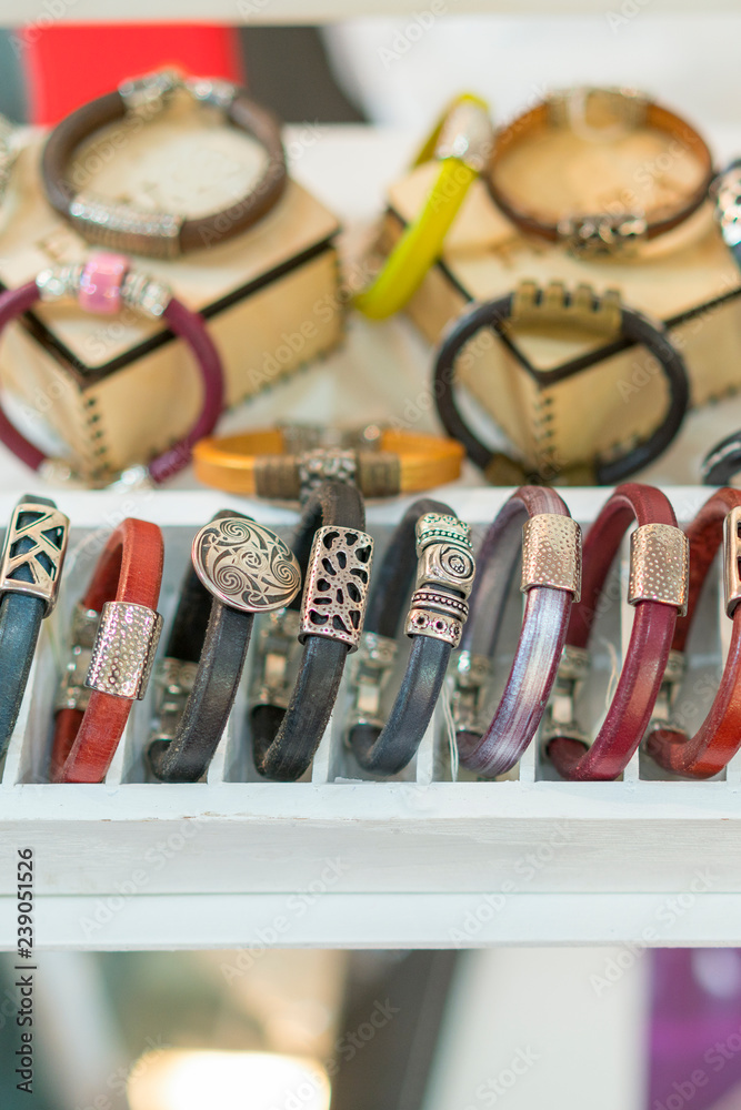 Stylish leather bracelets in the shop. Many various leather and textile bracelets. Leather multi-colored bracelets in the shop. vertical photo