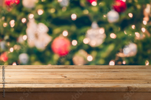 Christmas background with empty wooden table over festive bokeh Christmas tree decorations.