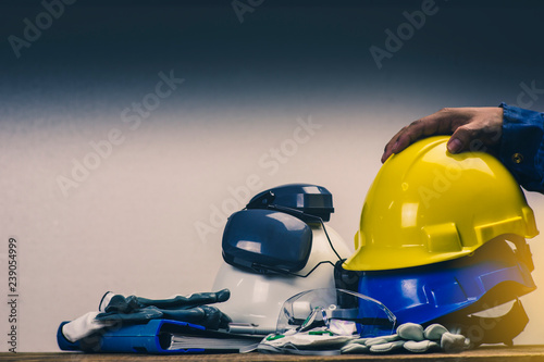 Works safety concept: PPE (Personal Protective Equipment), hard hat or industrial helmet for protection the worker from accident during working at construction site, factory or industry building. photo