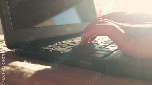 Hands of a Young Girl type on Notebook keyboard. HIghkey light. Dreamy mood