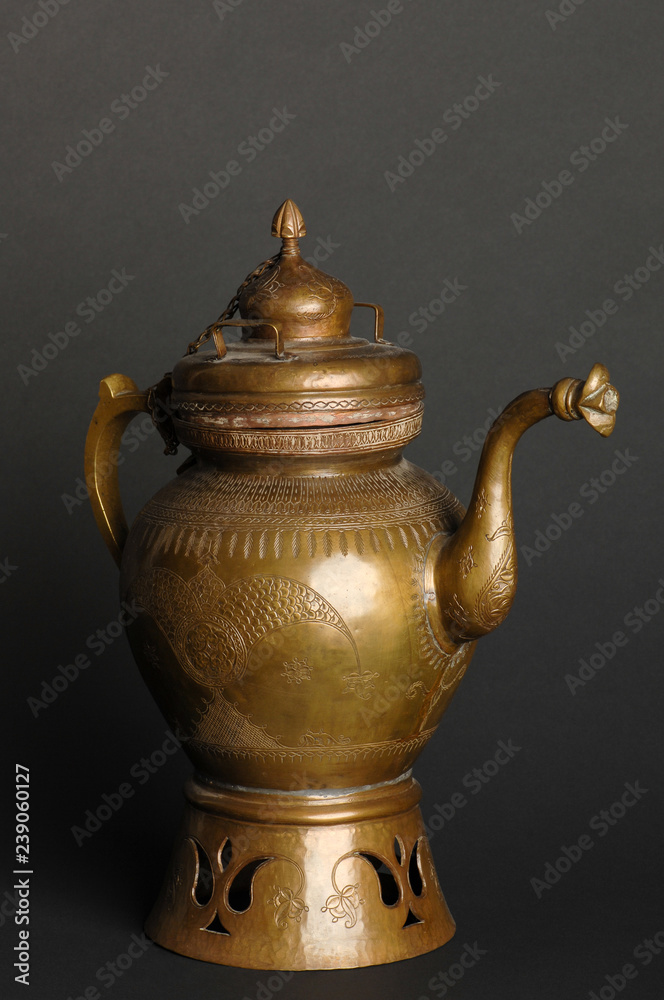 ancient oriental metal teapot on dark background. antique bronze tableware