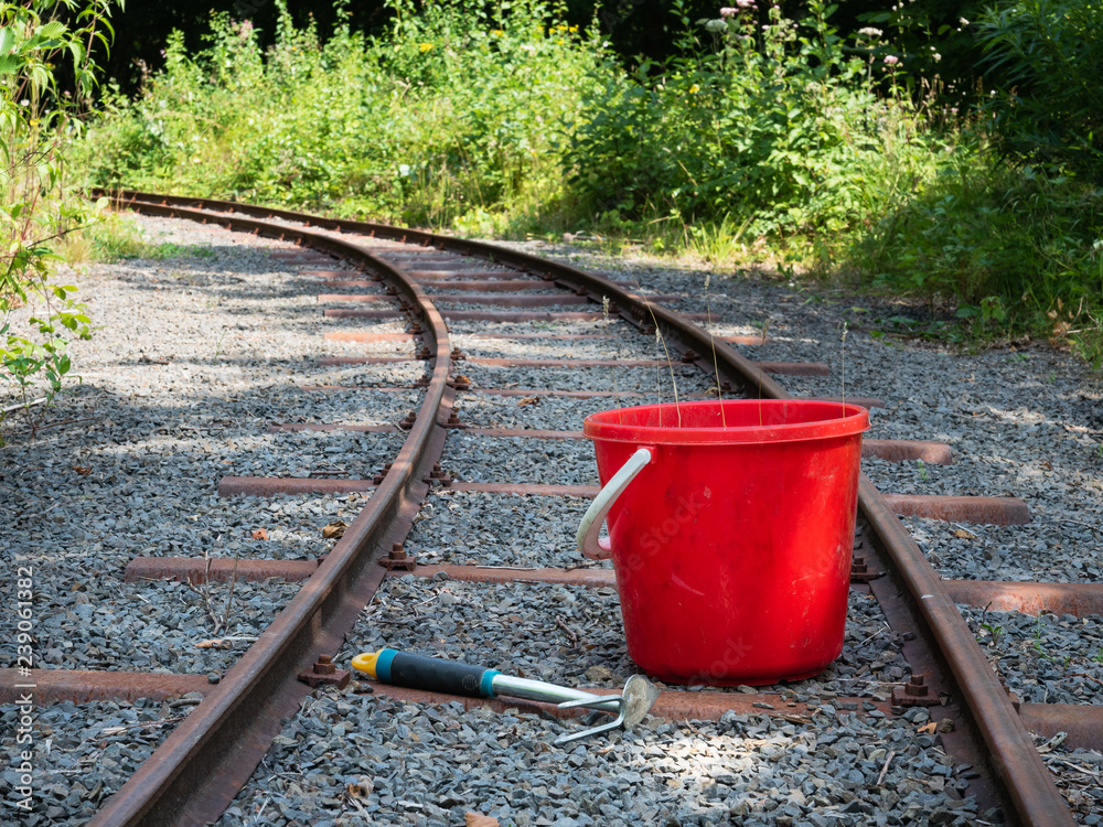 Worker's bucket beside small gauge railway tracks Worker's bucket beside small gauge railway tracks