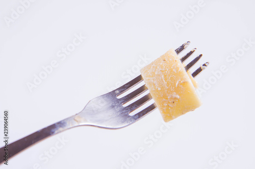 Pappardelle Carbonara on a fork on a white background