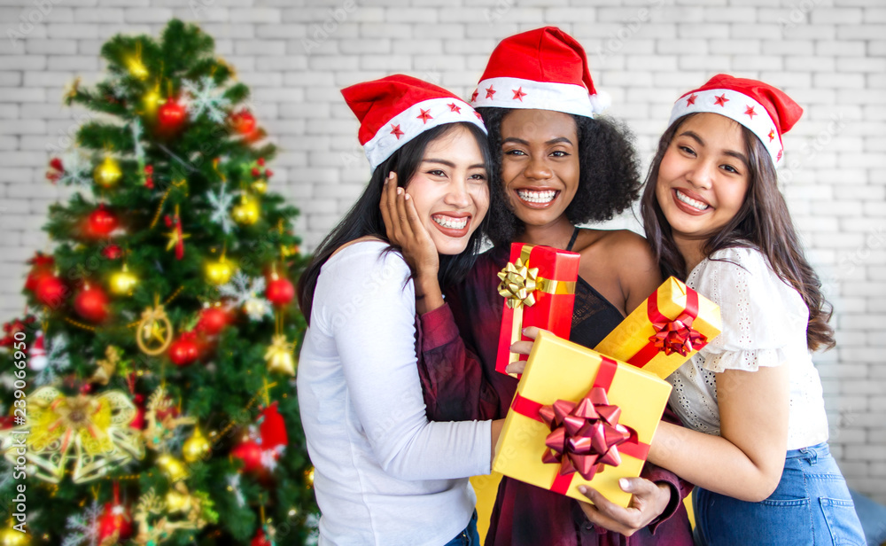 Three happy and beautiful girls celebrating in Christmas party at home
